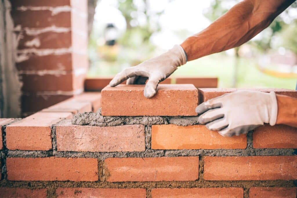 Man laying bricks for real residential construction project.